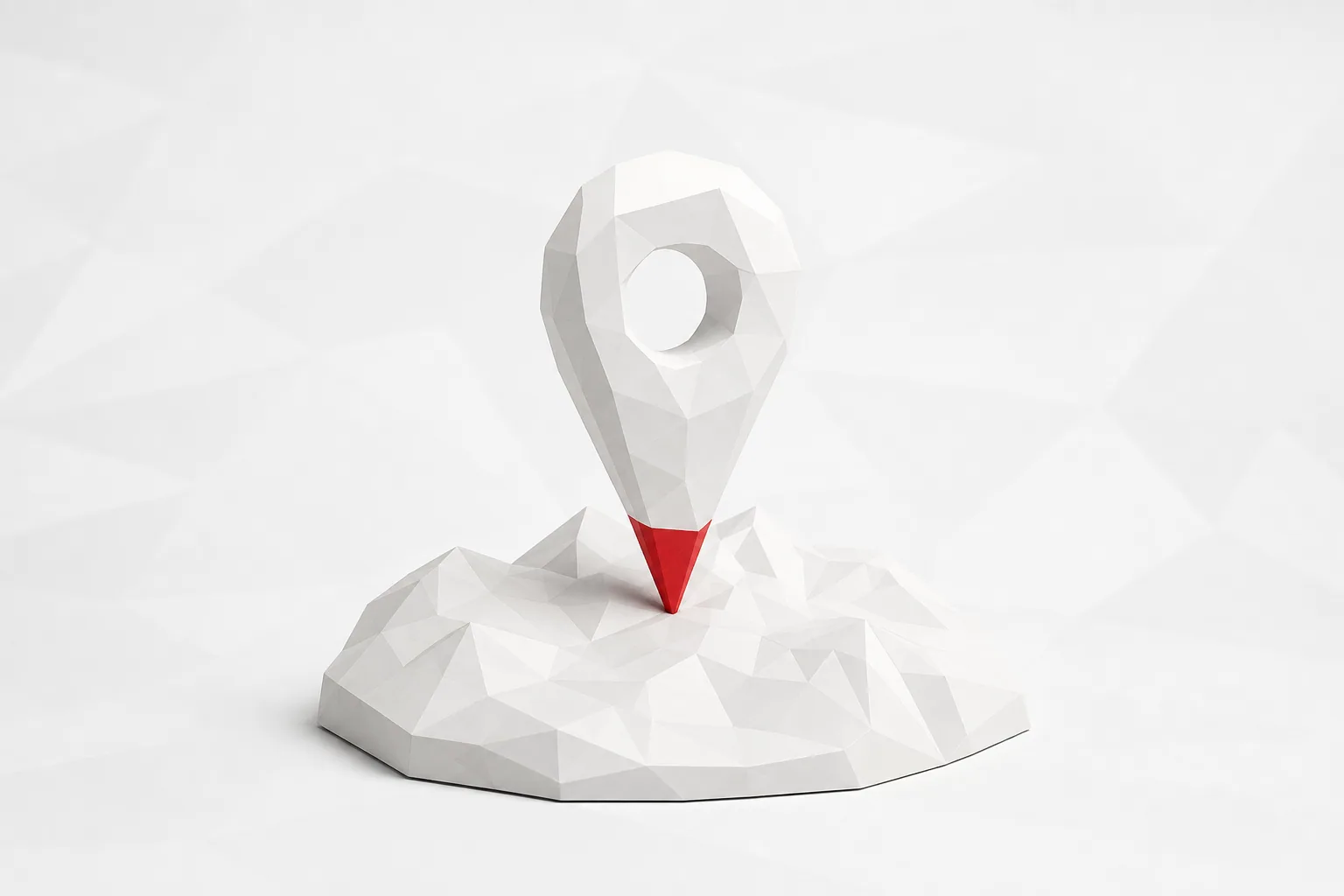 Un marcador de mapa facetado blanco con la punta roja, clavado sobre un relieve del mismo material