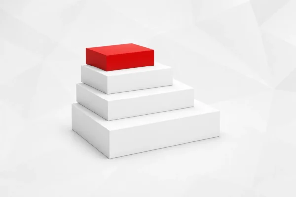 Cuatro bloques facetados apilados de mayor a menor formando una escalera, con el de arriba en rojo
